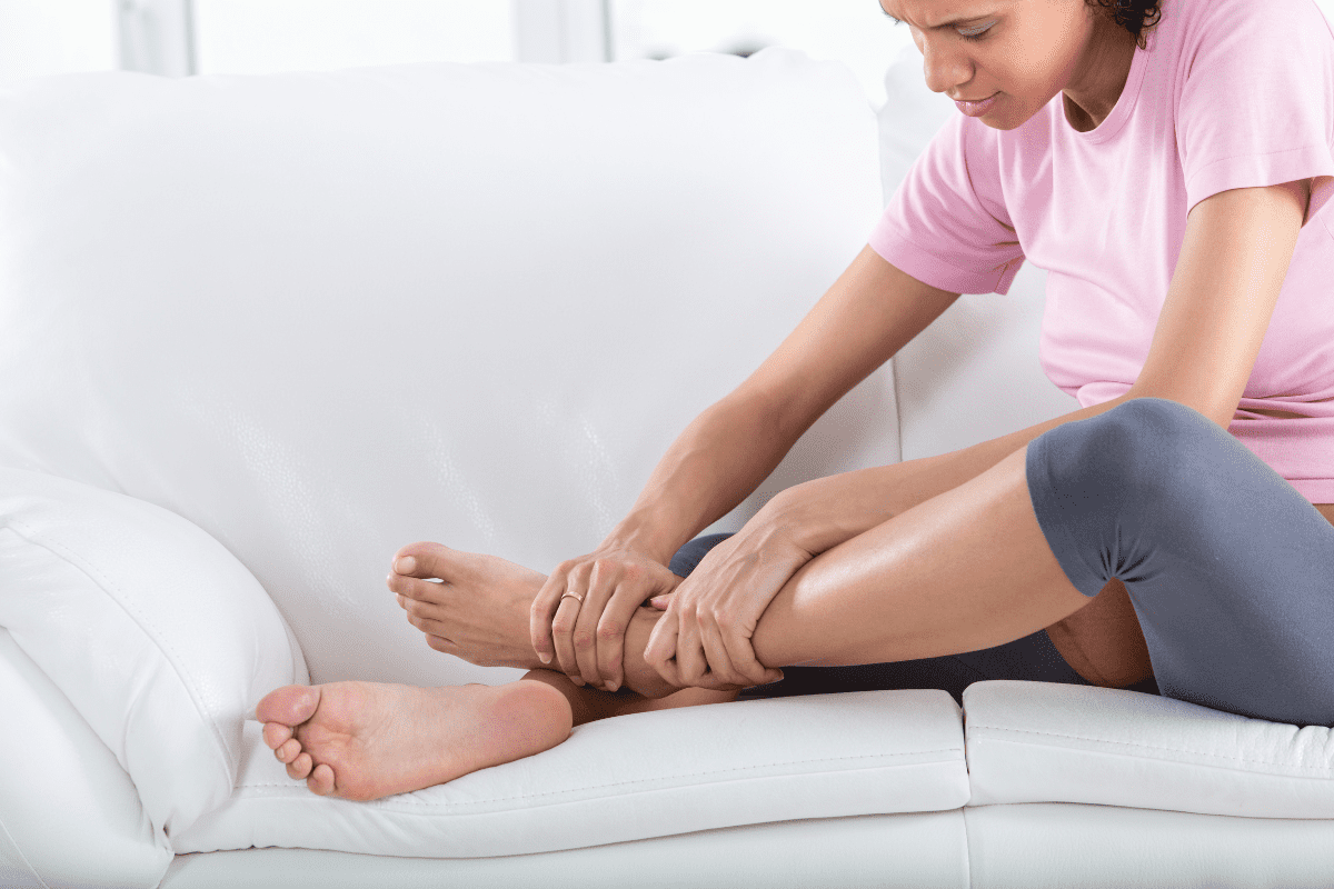 Women on couch examining feet massaging ankle